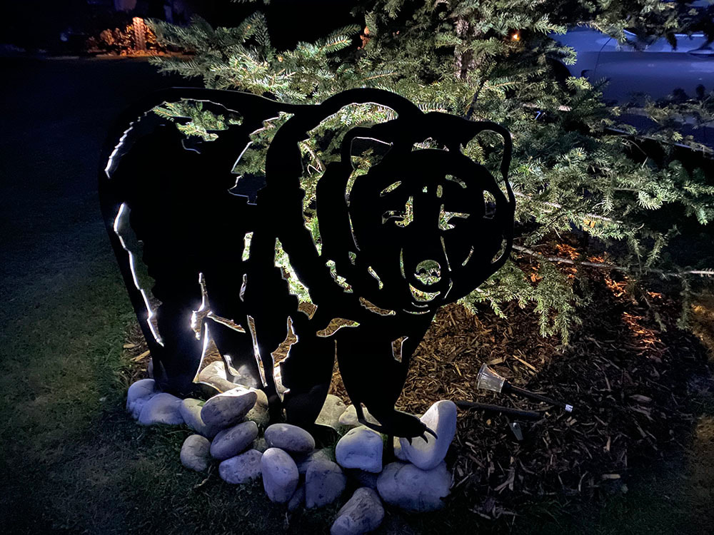 steel grizzly bear cut out lit at night
